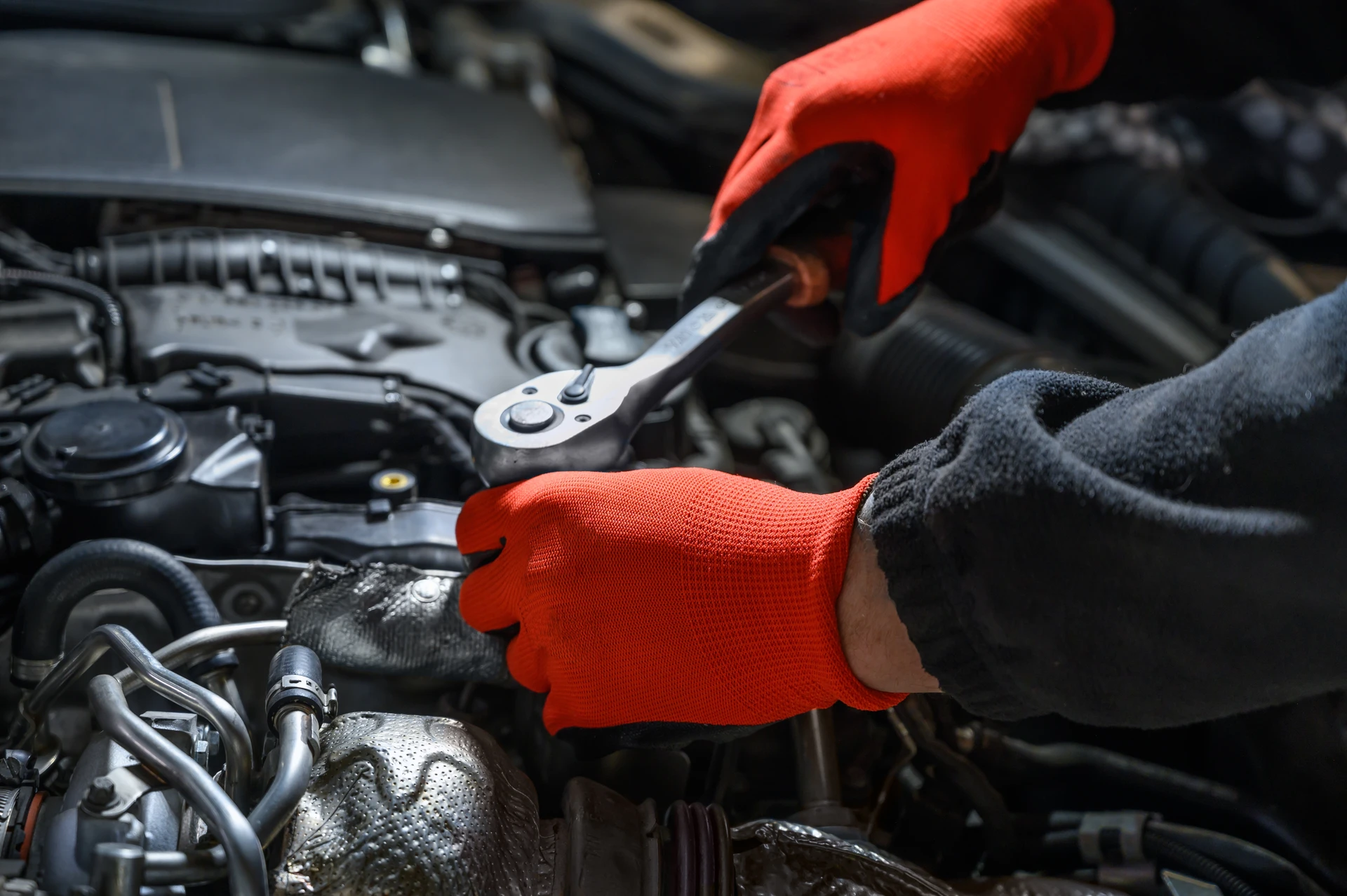 Mécanicien automobile en combinaison bleue effectuant un diagnostic électronique sur véhicule dans garage professionnel